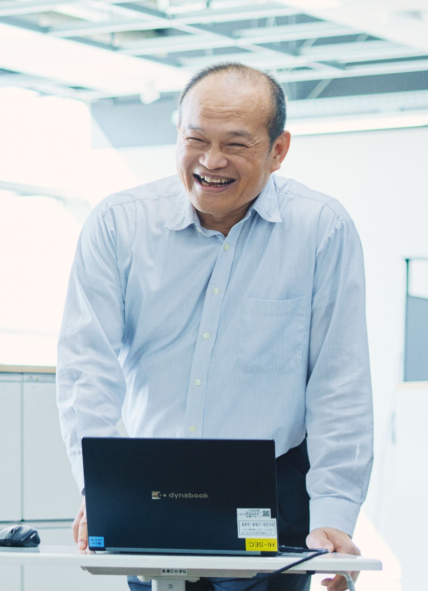 下肢障がいをもつ社員の劉銘祟さんが他の社員と打ち合わせをしている様子